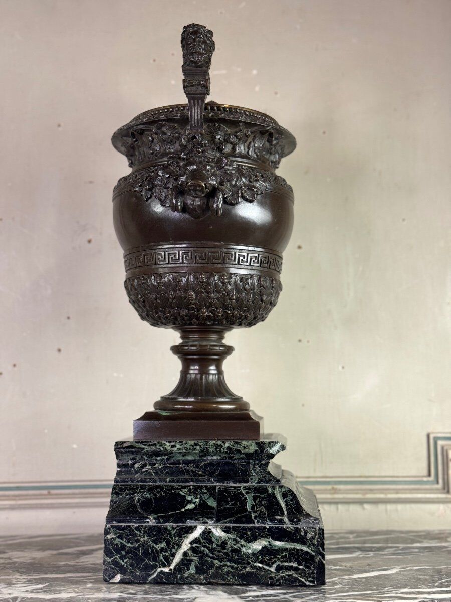 Patinated bronze vase with handles topped by bicéphalic busts, 19th century.