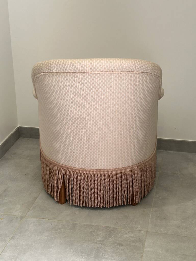 Pink armchair with patterns and fringes.