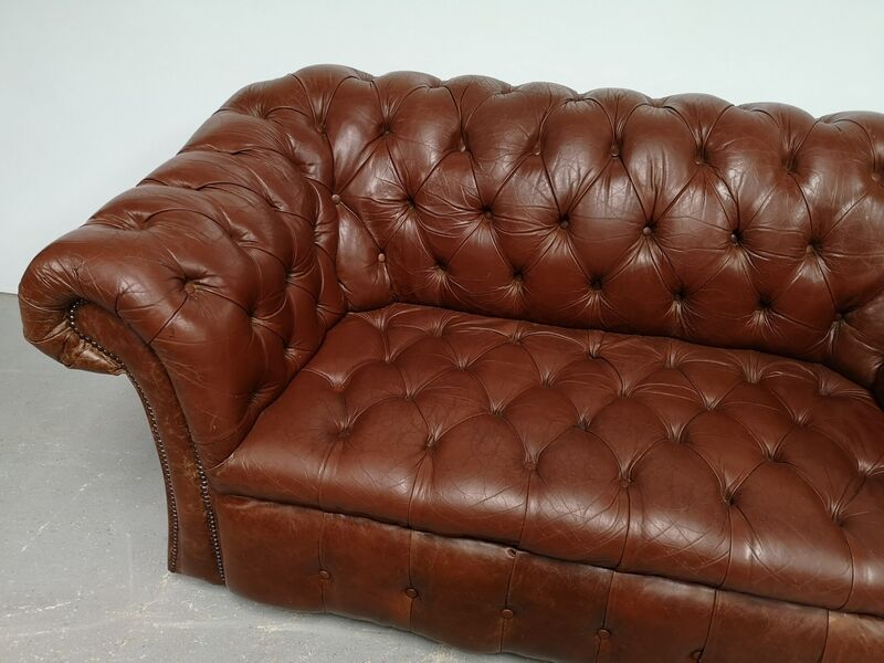 Two-seater brown leather chesterfield sofa