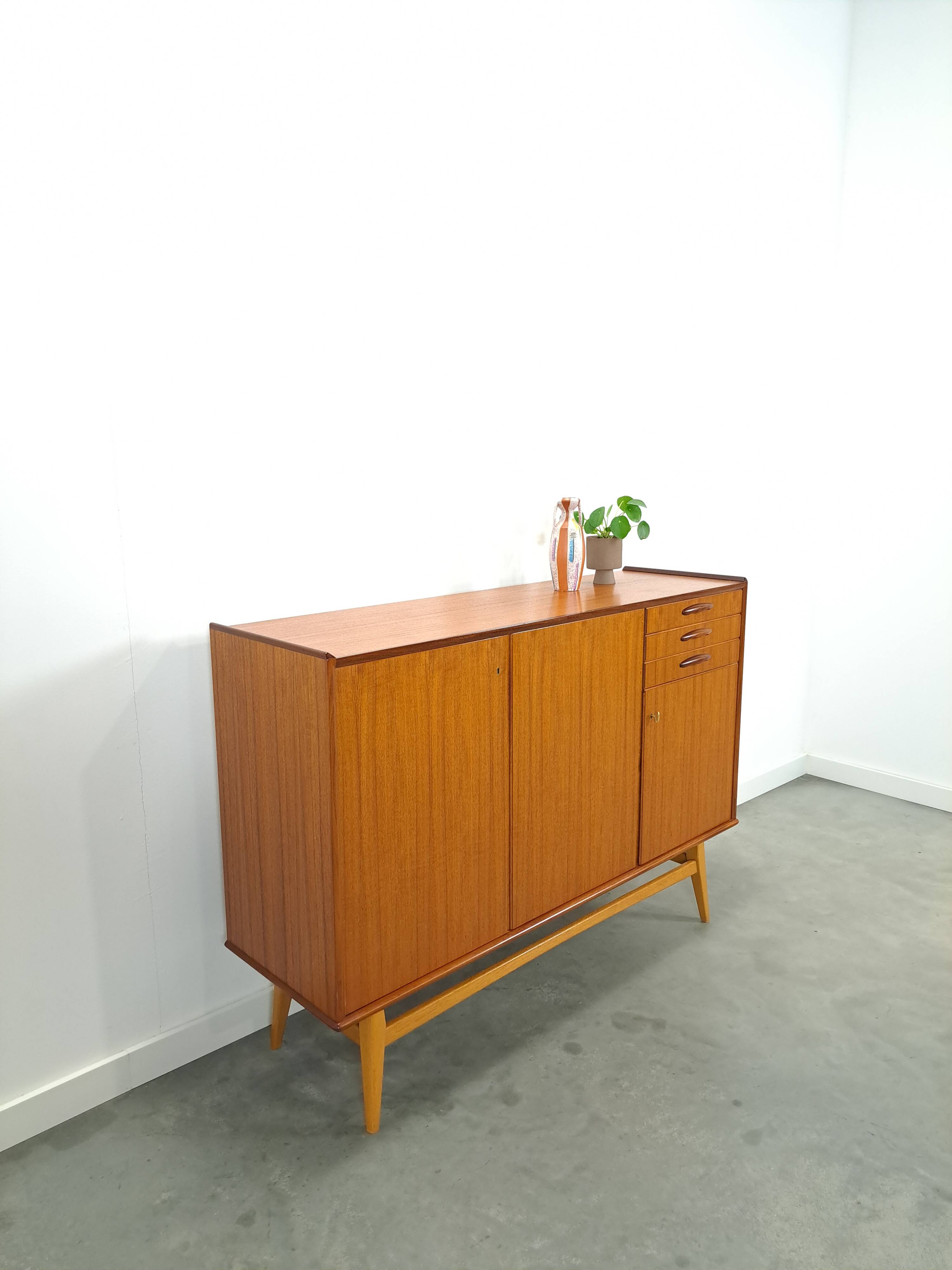 Teak kast met schuine poten en lades uit Zweden