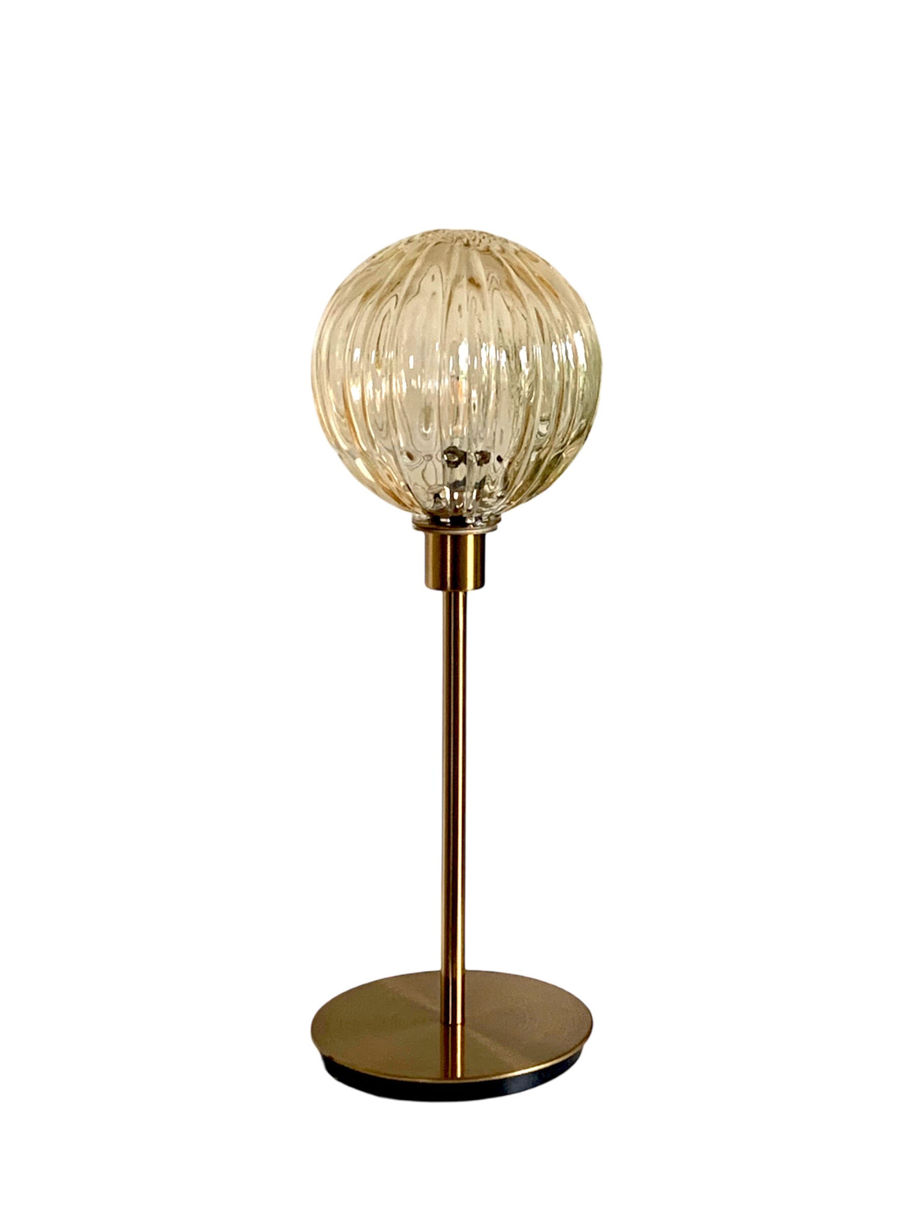 Table lamp with an antique golden streaked globe and a golden foot