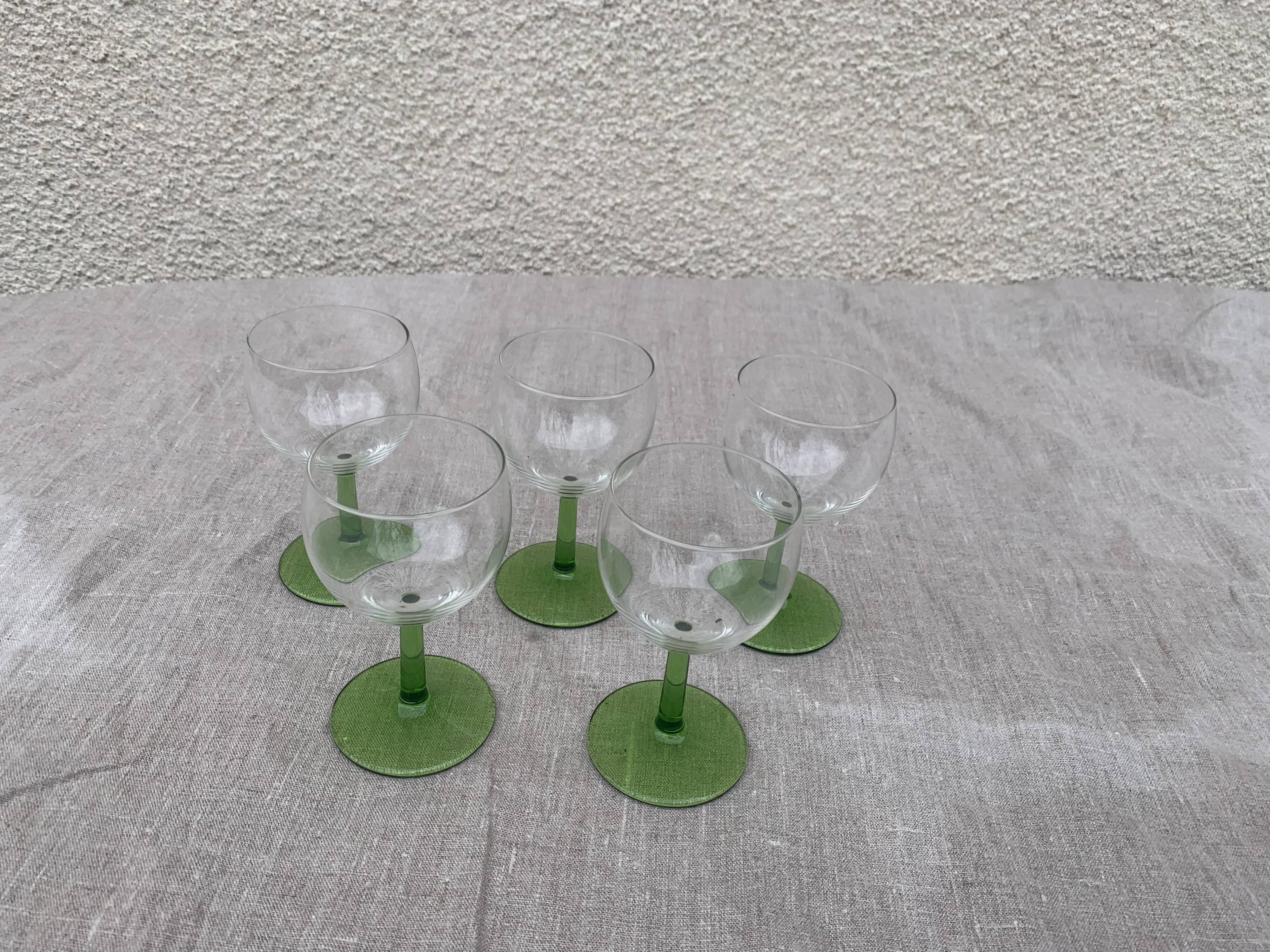 5 transparent glass glasses and green glass vase go