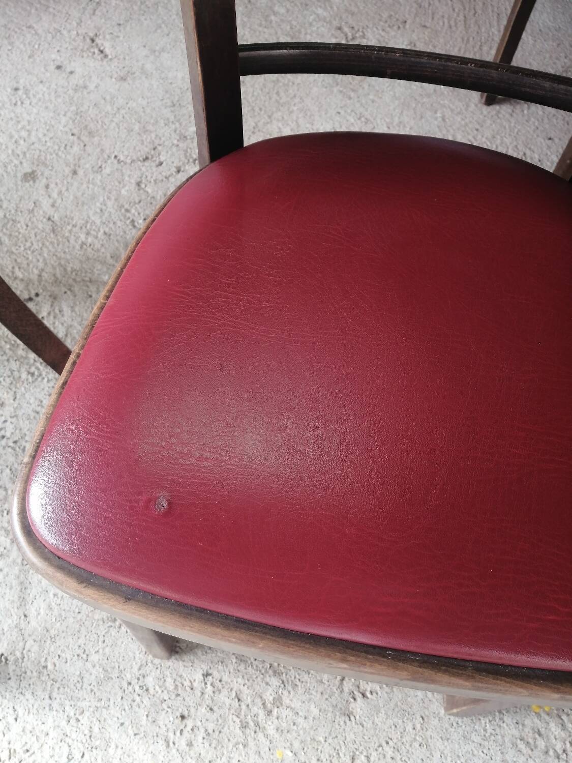 Set of 19 vintage wooden bistro chairs with red faux leather.