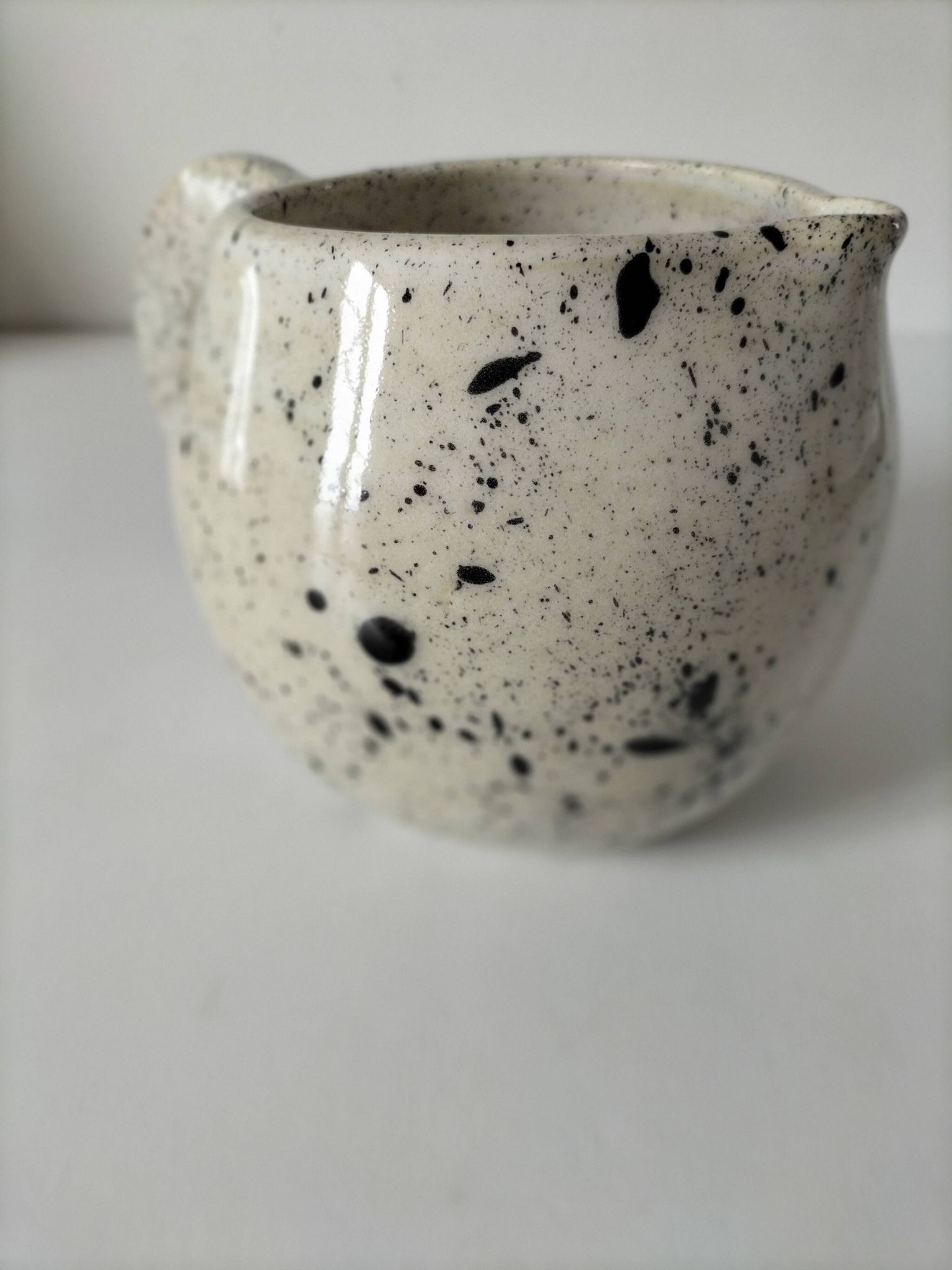 Small speckled ceramic jug in a vintage workshop style.
