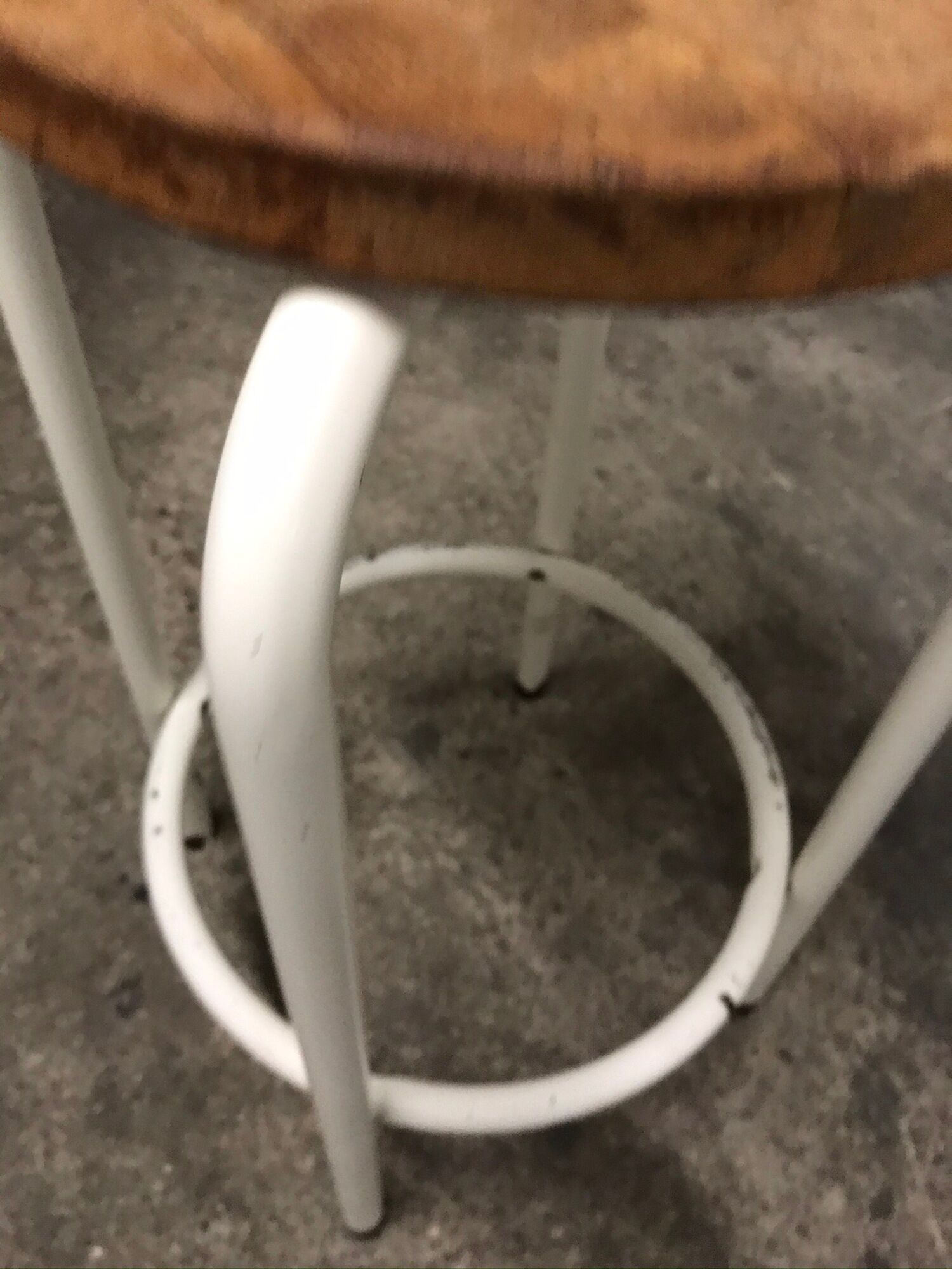 Vintage bar stool in white lace-up, round wooden seat rests circular feet