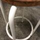 Vintage bar stool in white lace-up, round wooden seat rests circular feet