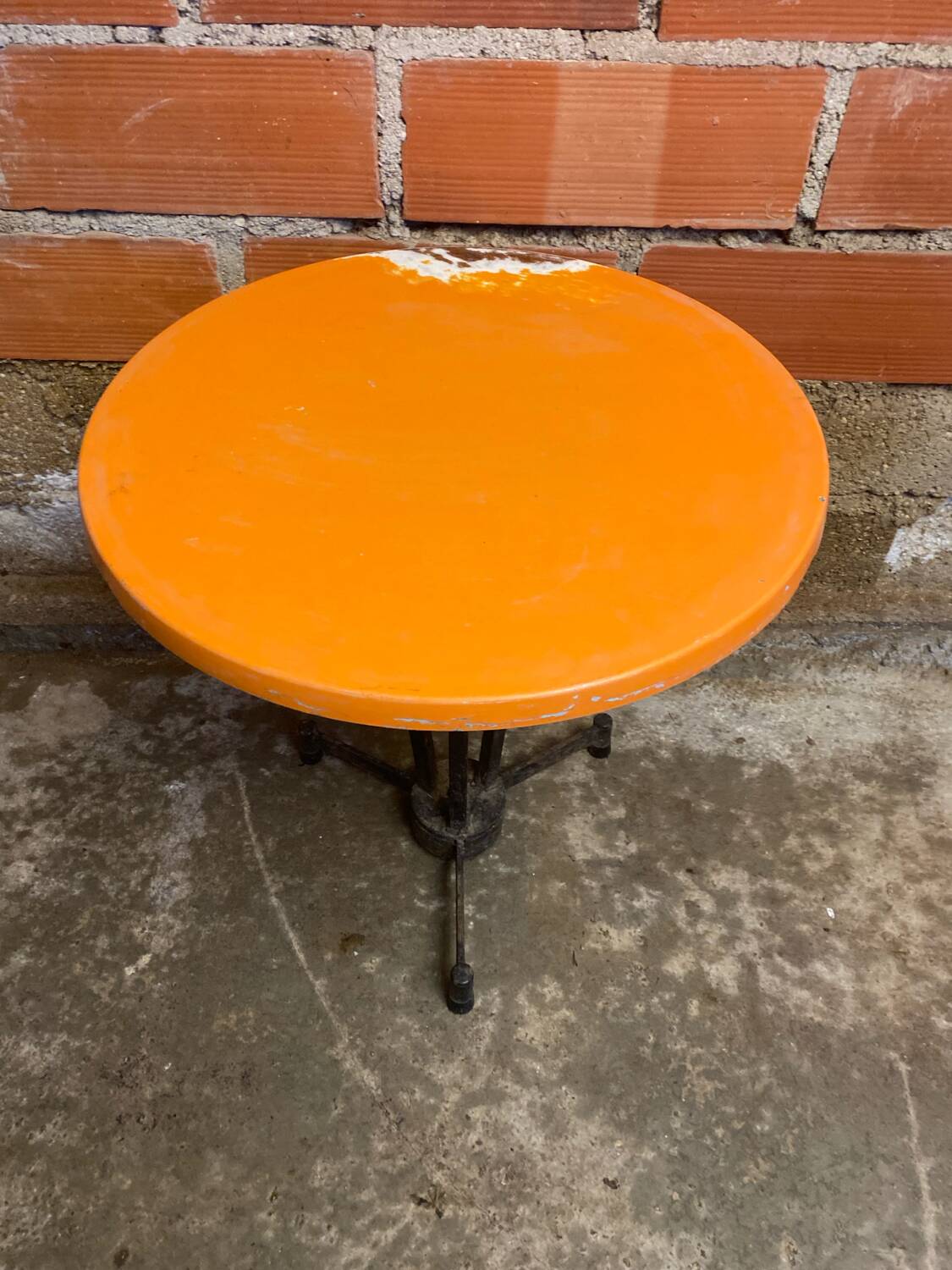 Vintage bistro table with black cast iron base and orange bakelite top, 1950s