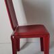 Red leather dining chairs by Arper