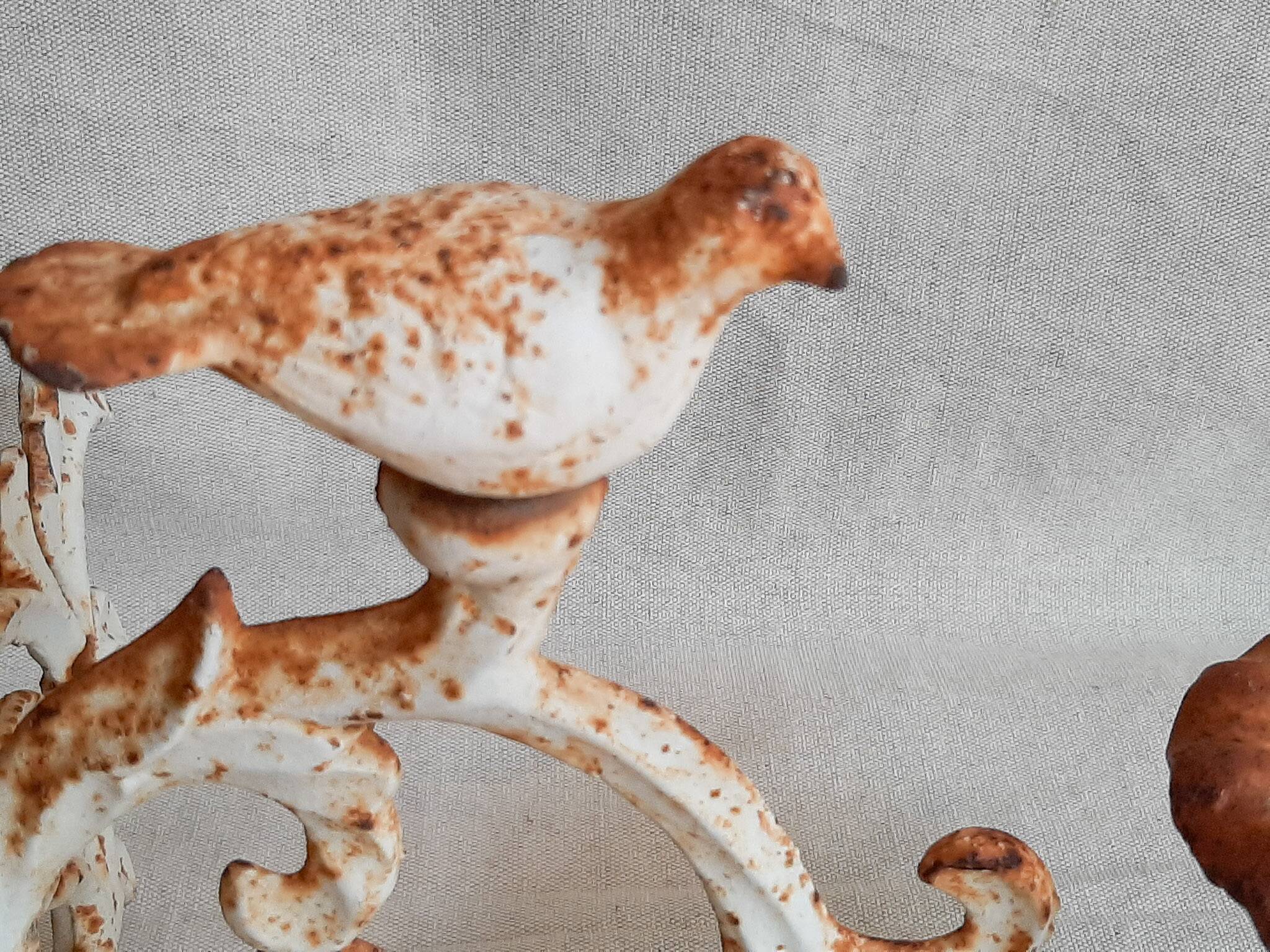 Wall lamp in antique cast iron with bird and scroll decorations.