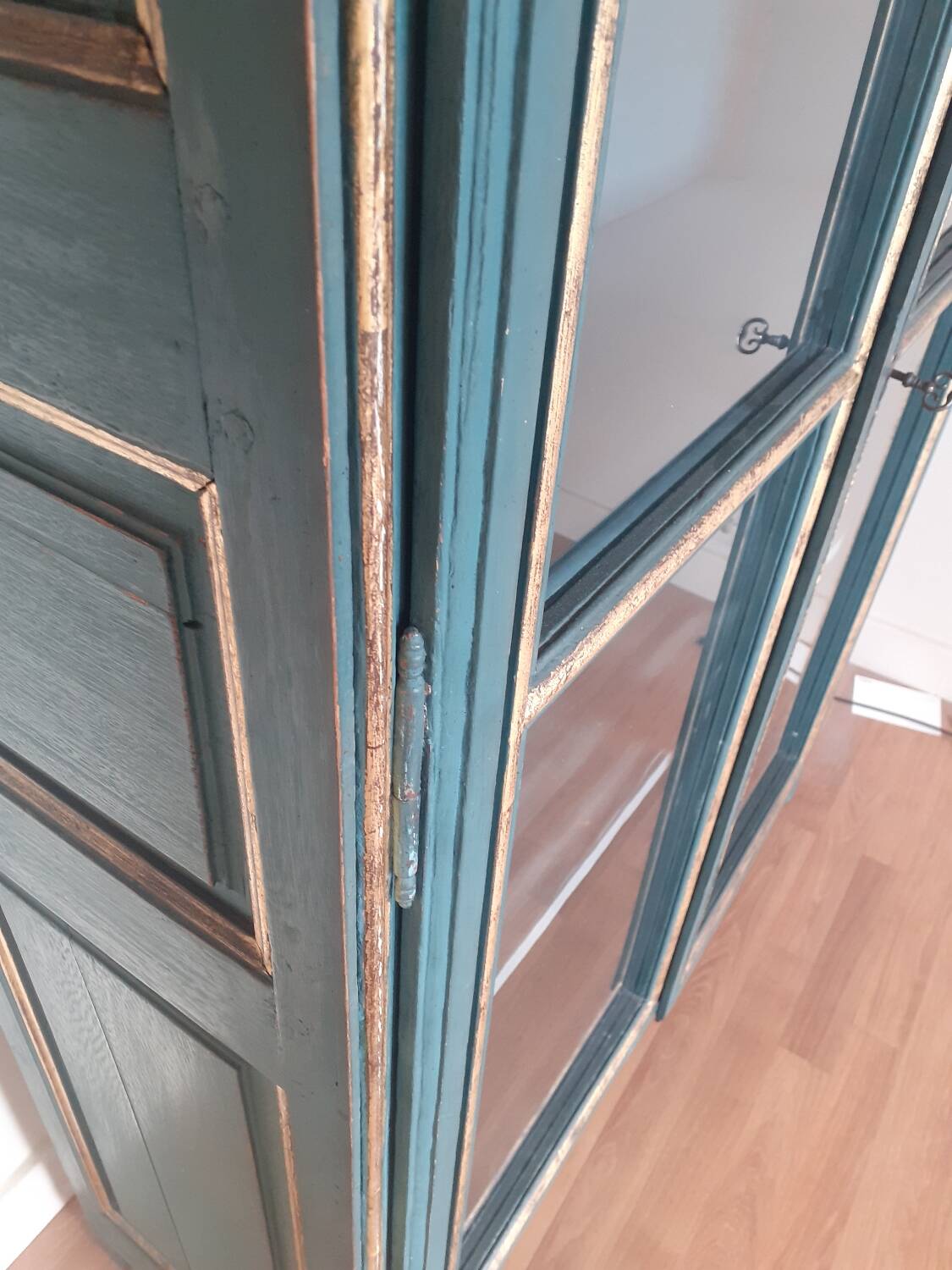 Glass-fronted cabinet in weathered green wood