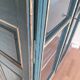 Glass-fronted cabinet in weathered green wood
