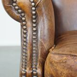 Cognac-colored sheepskin wing chair in English style