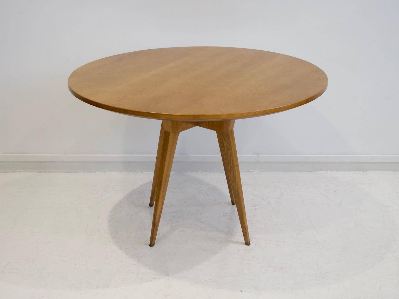 Round dining table in Wood Wood with brass details.