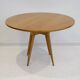 Round dining table in Wood Wood with brass details.
