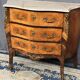 Louis XV style commode with rosewood veneer, gilded bronze mounts, and marble top.