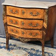 Louis XV style commode with rosewood veneer, gilded bronze mounts, and marble top.