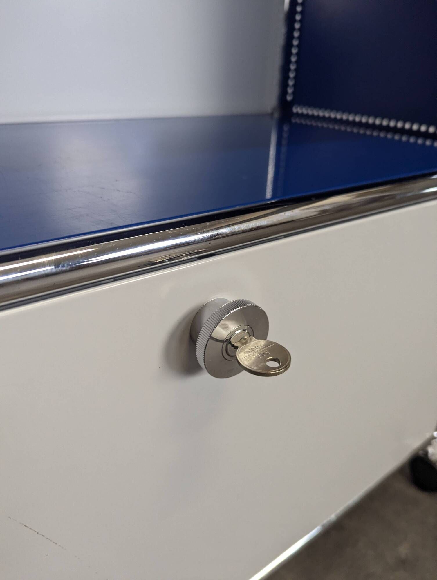 USM Haller furniture in gentian blue and white with a drop-down door on wheels.