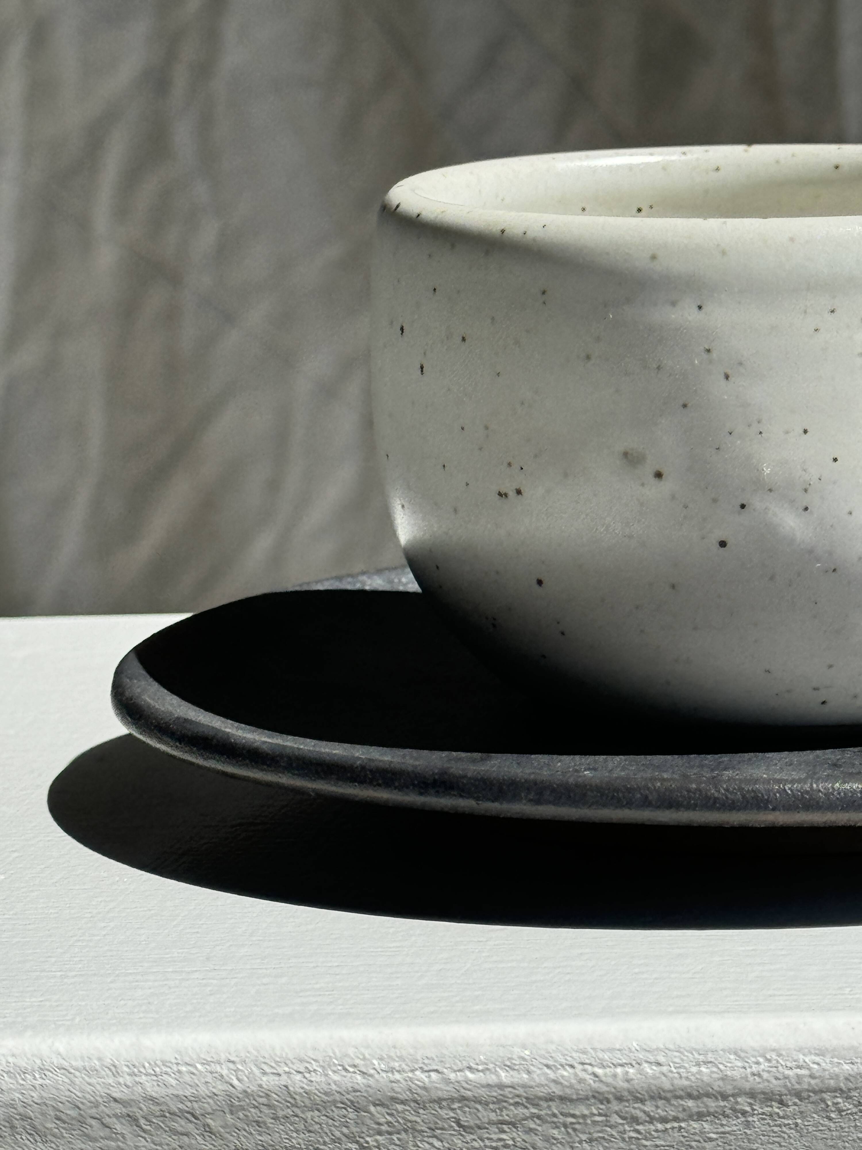 White Indonesian ceramic cup and gray saucer