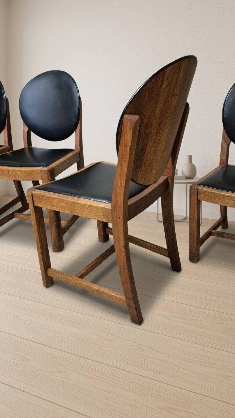 Set of four vintage wooden dining chairs with black leather upholstery