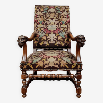 Renaissance armchair in carved walnut decorated with lion heads on the armrests, 19th century