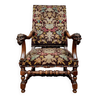 Renaissance armchair in carved walnut decorated with lion heads on the armrests, 19th century