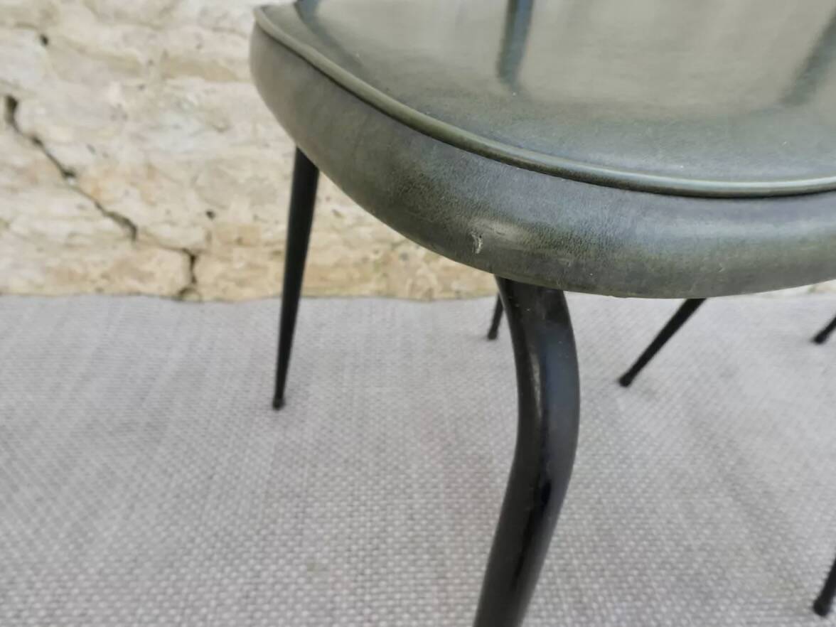 Black metal chairs with khaki faux leather seats, circa 1960.