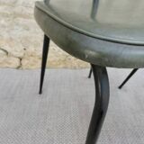 Black metal chairs with khaki faux leather seats, circa 1960.