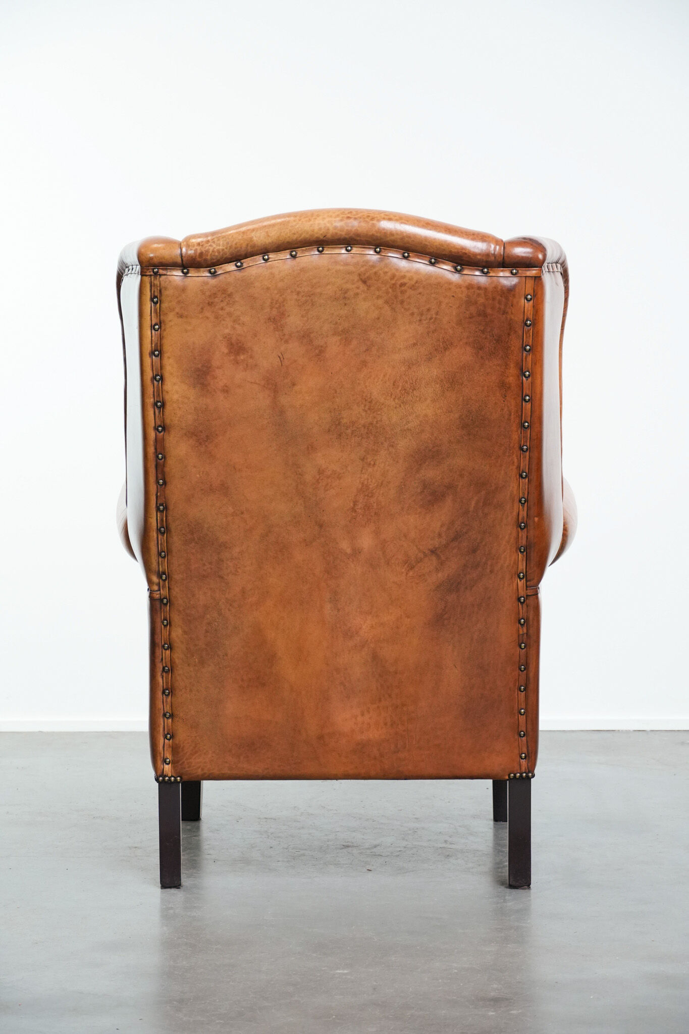 Wingback chair made of sheep leather with black piping in good condition