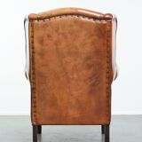 Wingback chair made of sheep leather with black piping in good condition