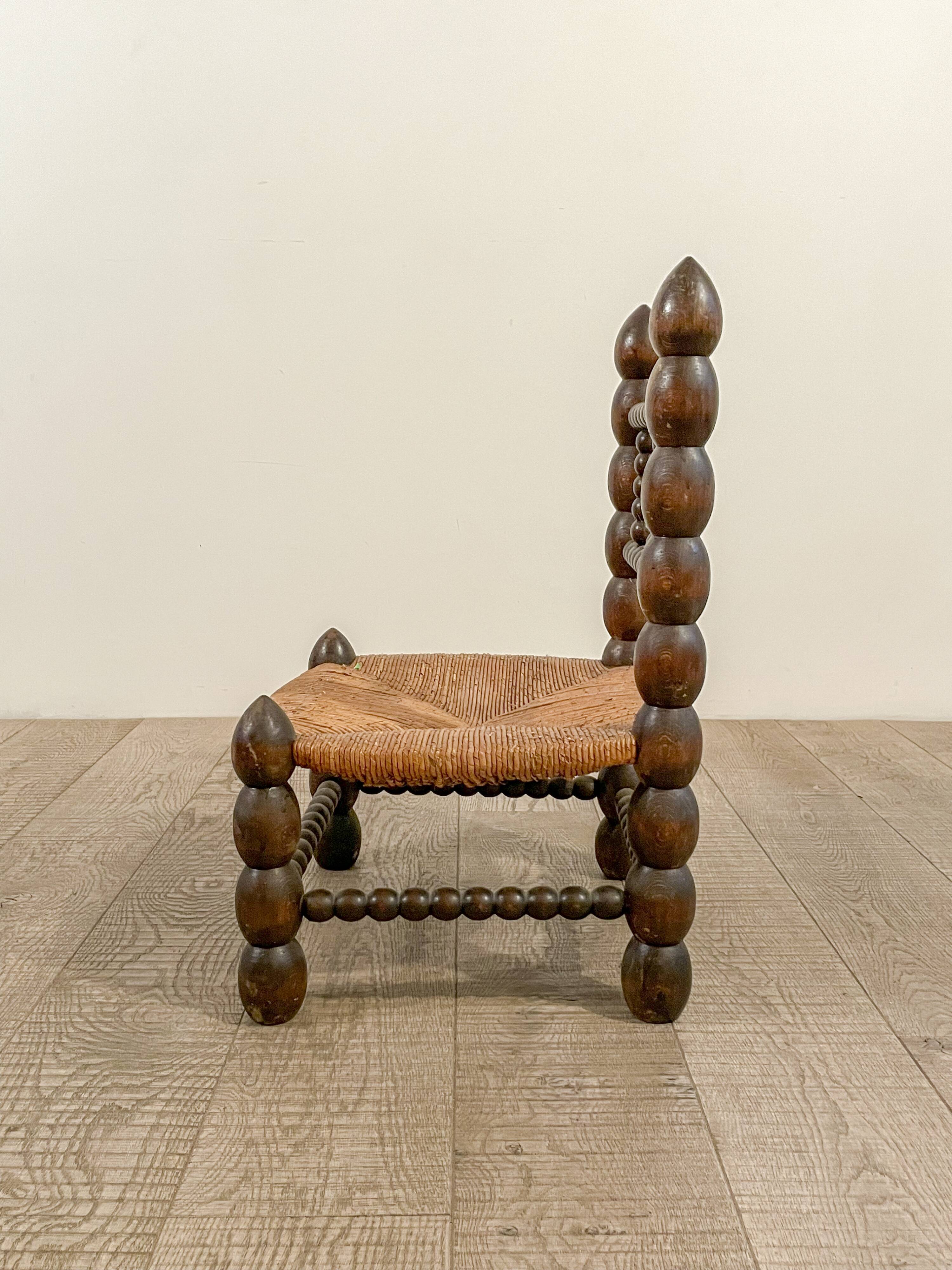 Low chair in beaded wood and straw
