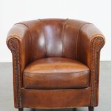 Sheep leather club chair in a cognac color and finished with piping
