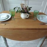 Walnut table with raised flaps, base on verdigris casters.