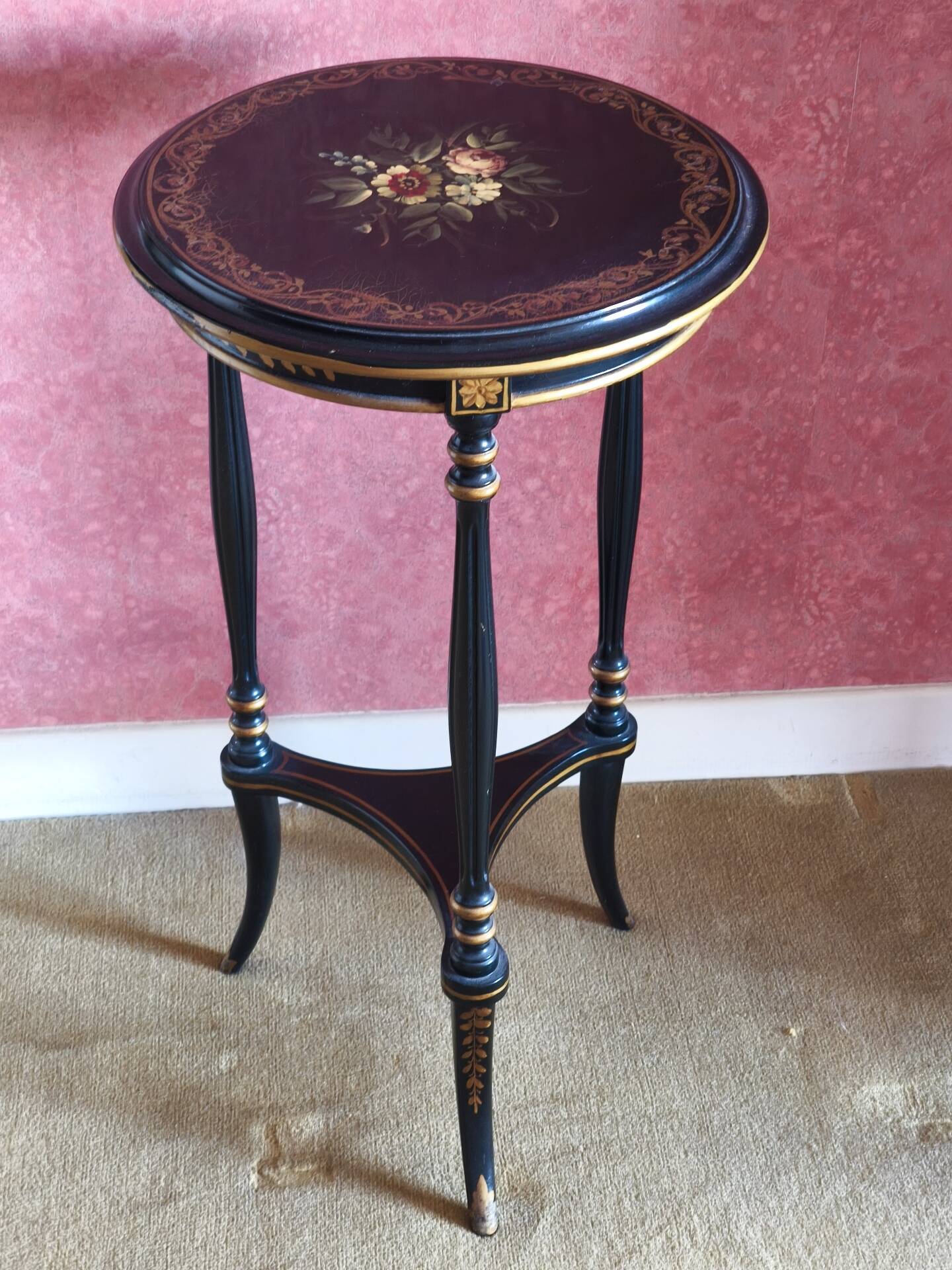 Tripod stool in blackened wood with painted floral decoration.