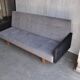 Mid-Century 1960s canapé in grey fabric with black armrests, natural wood base.