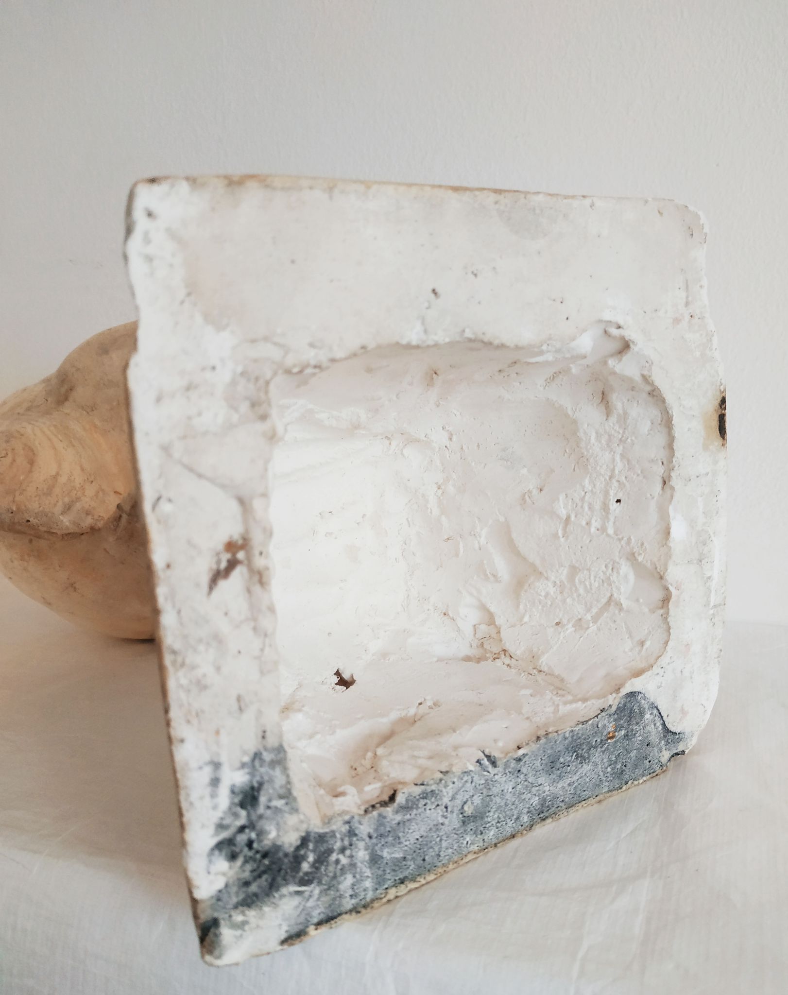Bust of woman in plaster on pedestal with inscription