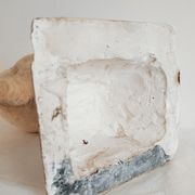 Bust of woman in plaster on pedestal with inscription