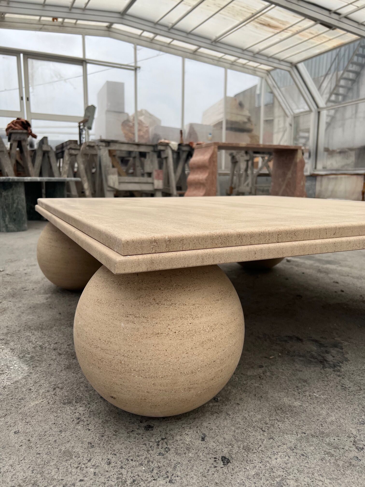 Square stone coffee table with sculptural ball legs