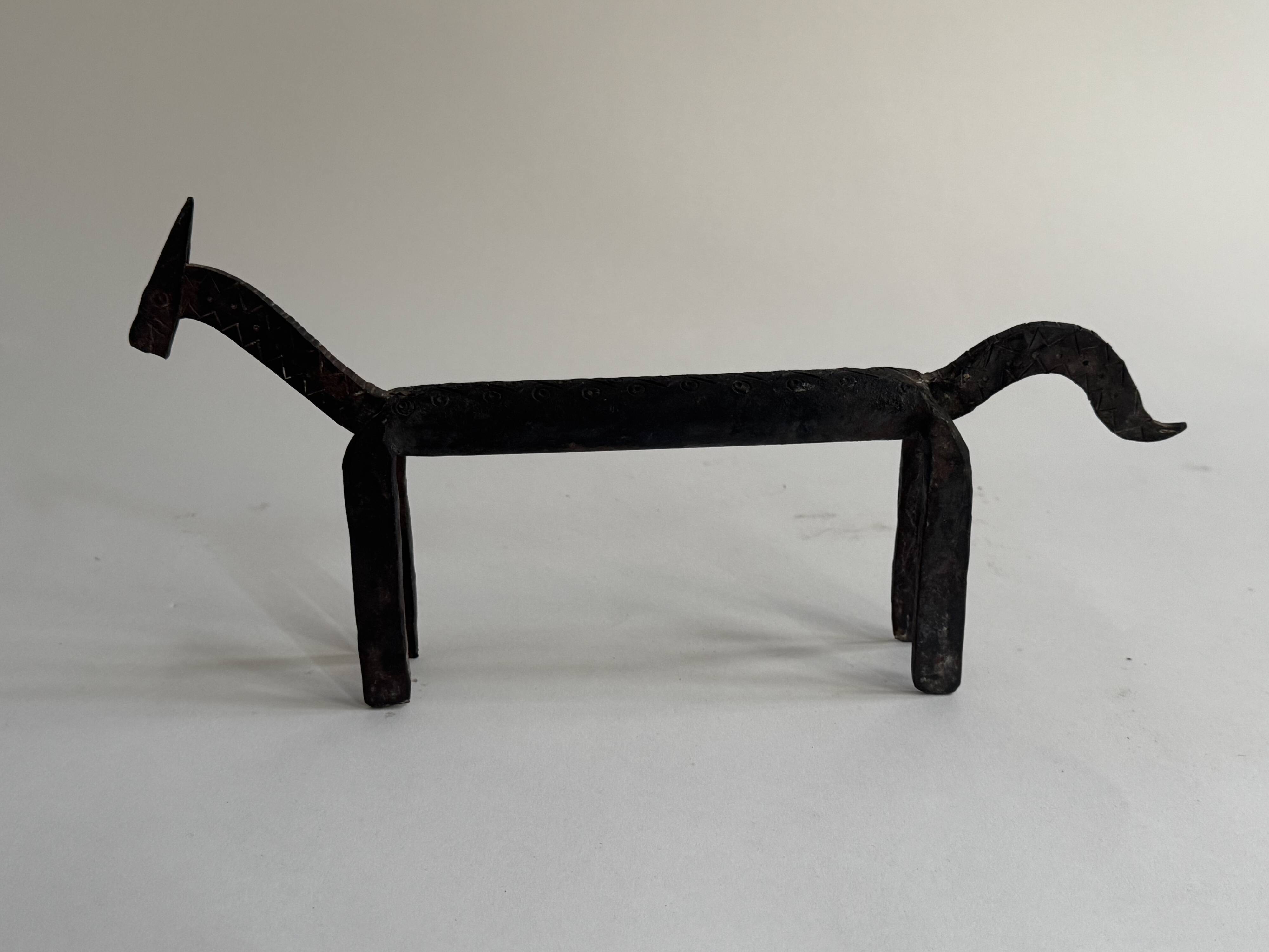 Pair of animal-shaped wrought iron and hammered fire dogs in primitive brutalist style.