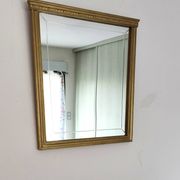 Miroir en bois doré, de forme organique avec une glace biseauté