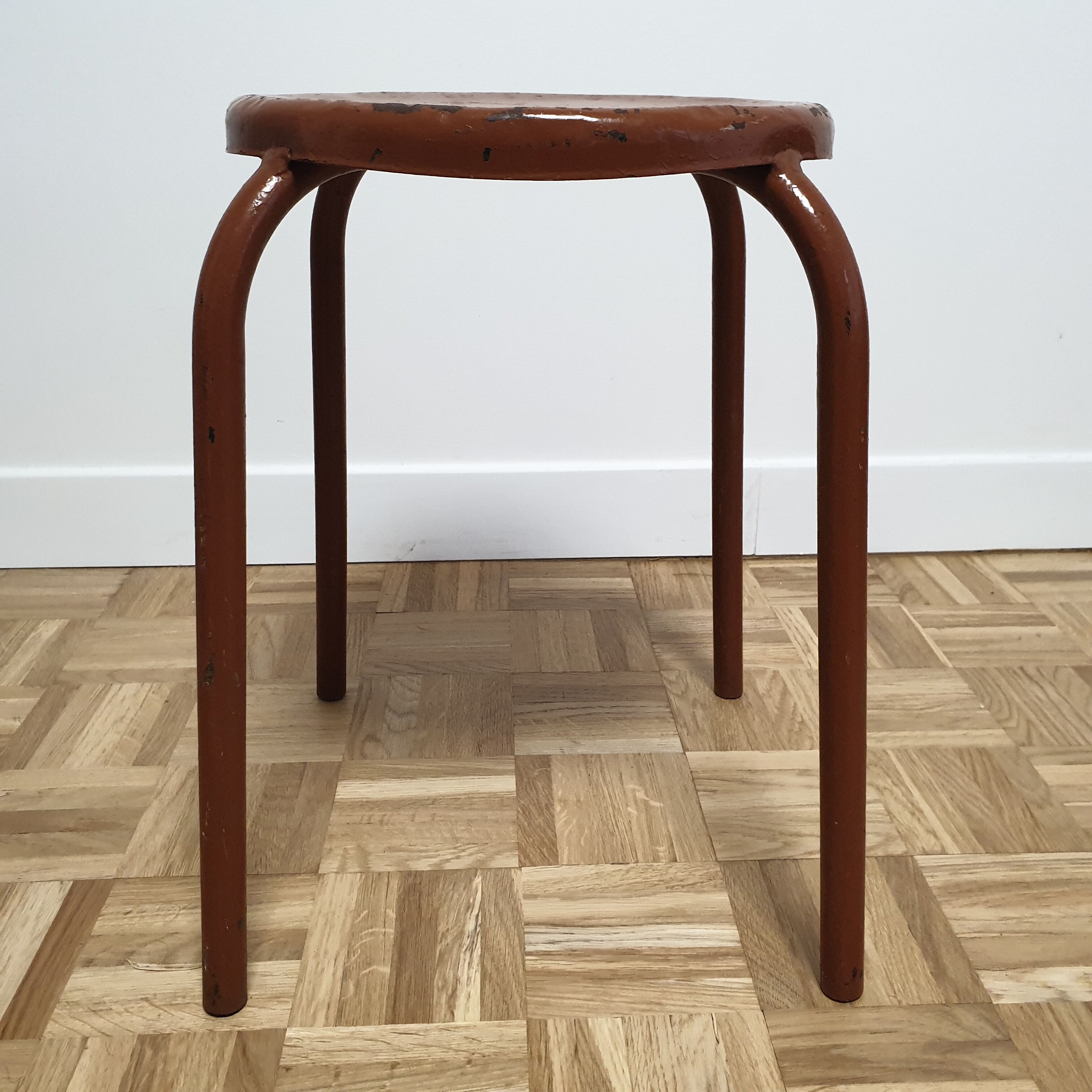 Rust-colored painted metal stool
