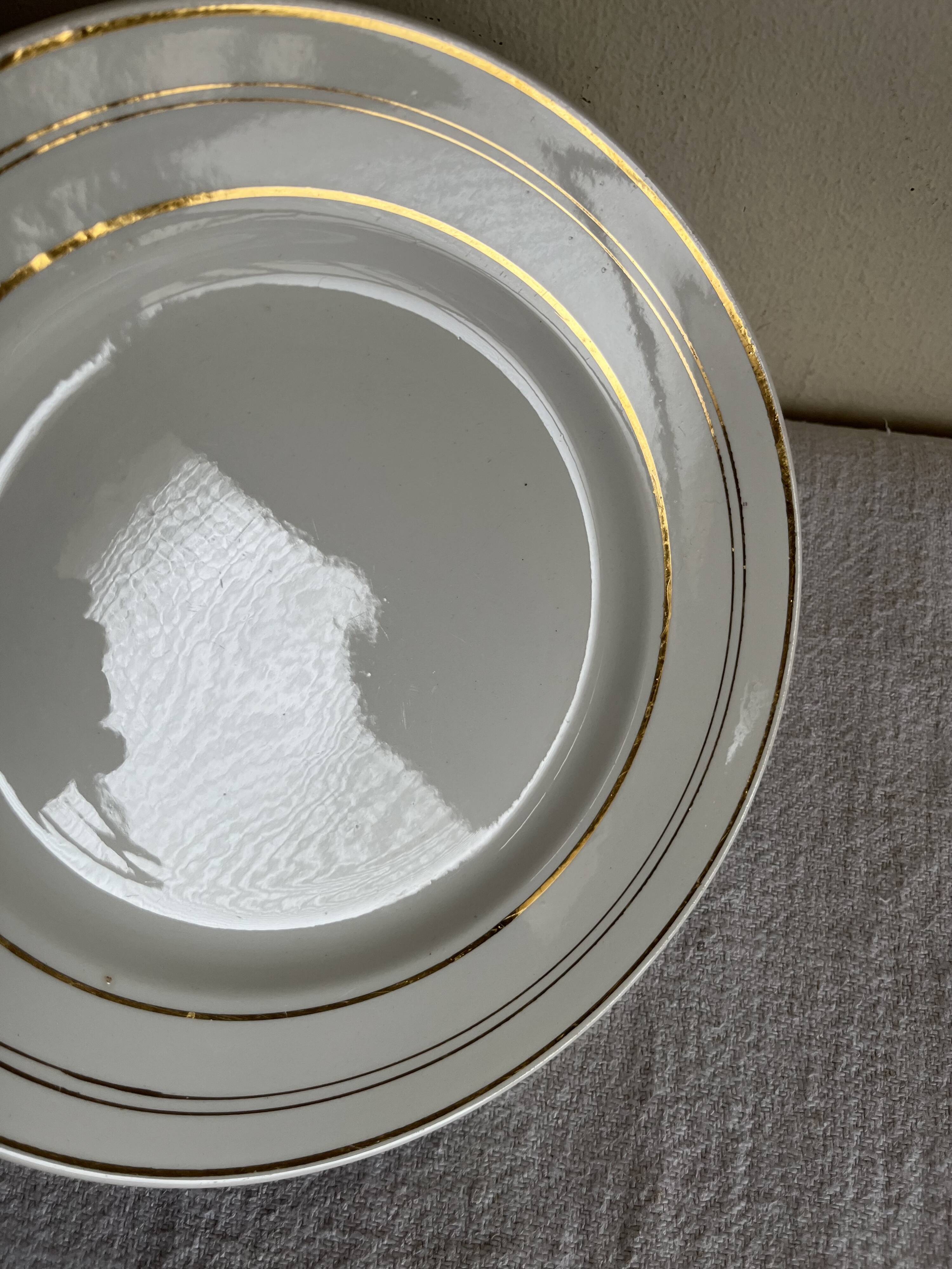 Set of 8 modernist flat plates in fine earthenware with pure gold trim, 1930.