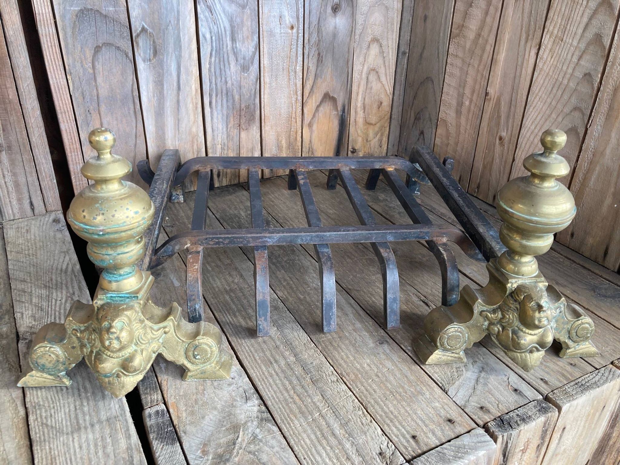 Pair of andirons and grates in cast iron and bronze with gilded grotesques, 17th century