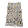 White carpet with Berber patterns gray blue and yellow woven hands