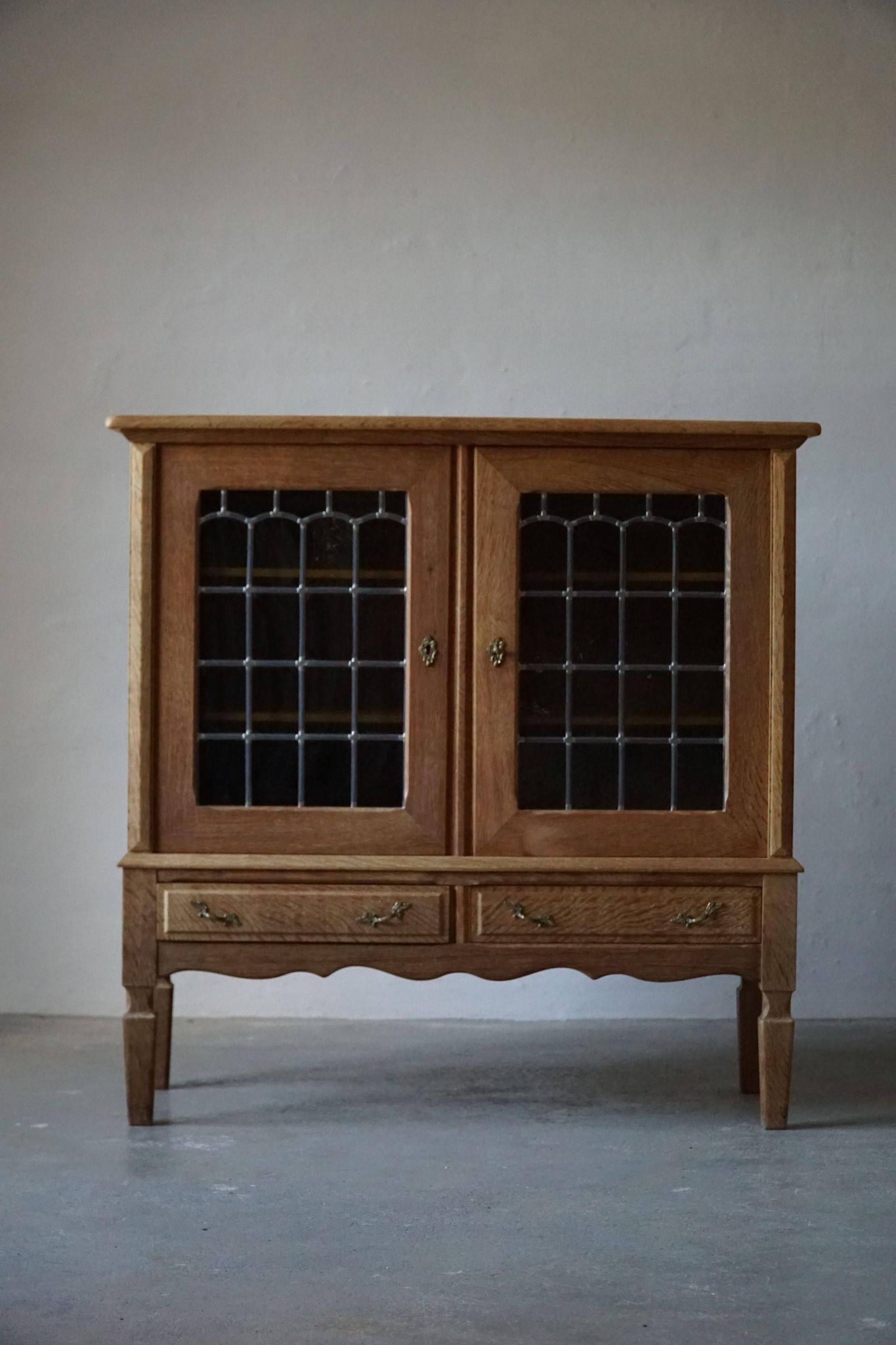 20th-century mid-century solid oak sideboard with glass front, by a Danish cabinetmaker.