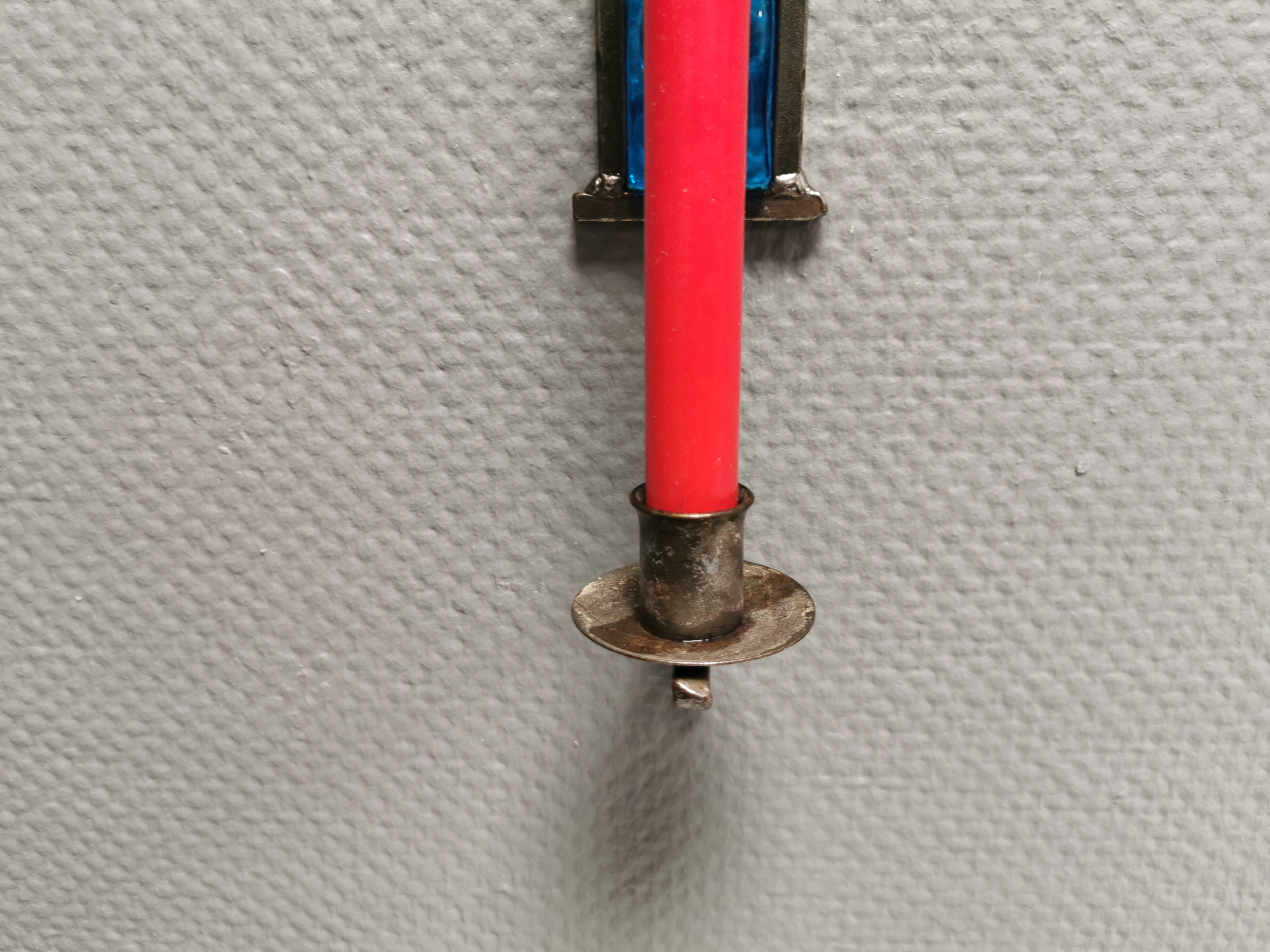 Wall-mounted candle holder in cast iron and hard pressed blue glass.