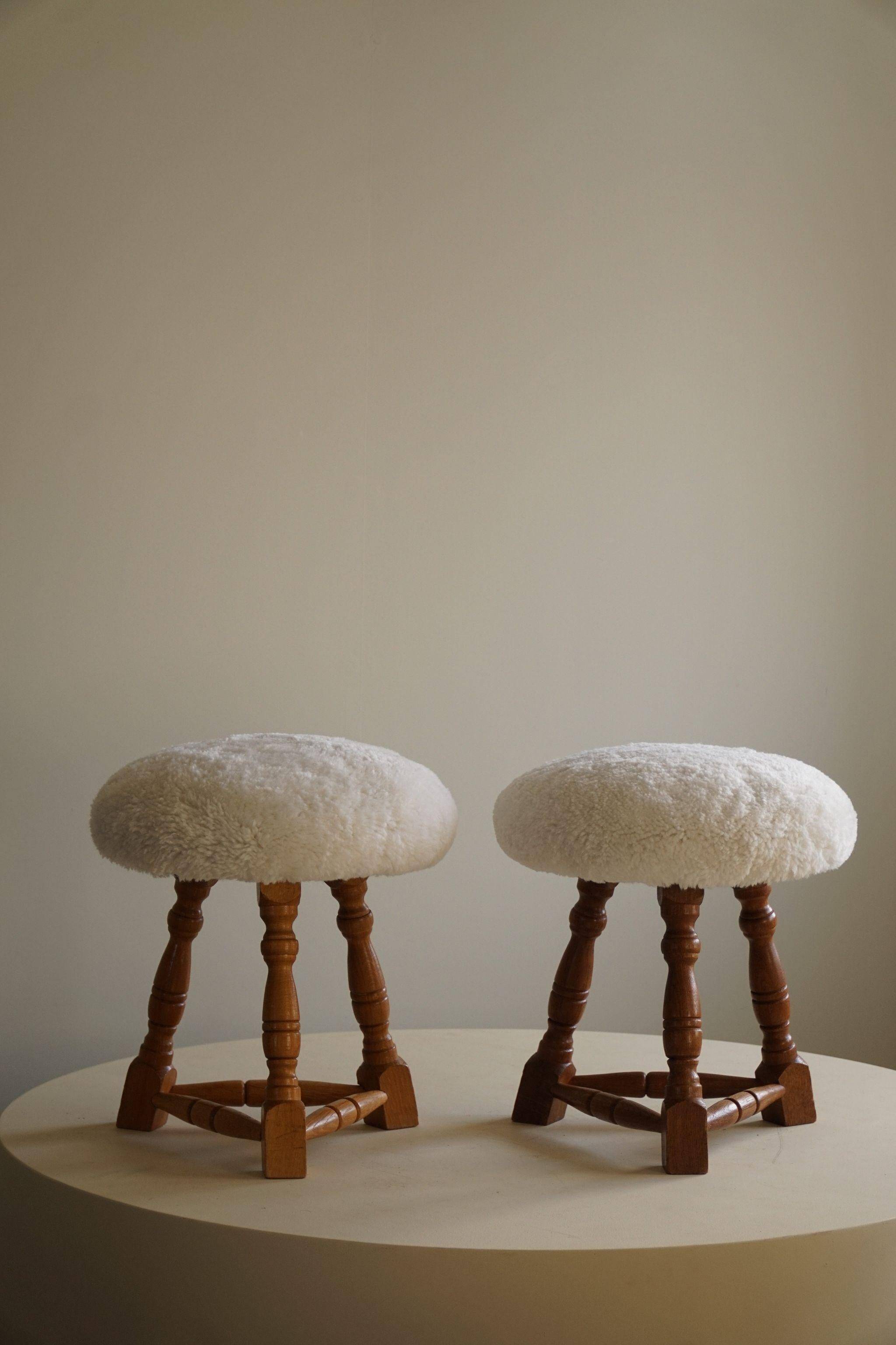 Modern Danish, a pair of tripod stools, seats reupholstered in lambswool, 1950s.
