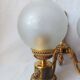 Wall lamp in gilded bronze with a lion's head and engraved globe.