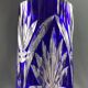 Tubular vase on a pedestal in cut blue Bohemian crystal.