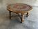 Vintage wooden turned coffee table with leather and astrological decoration.
