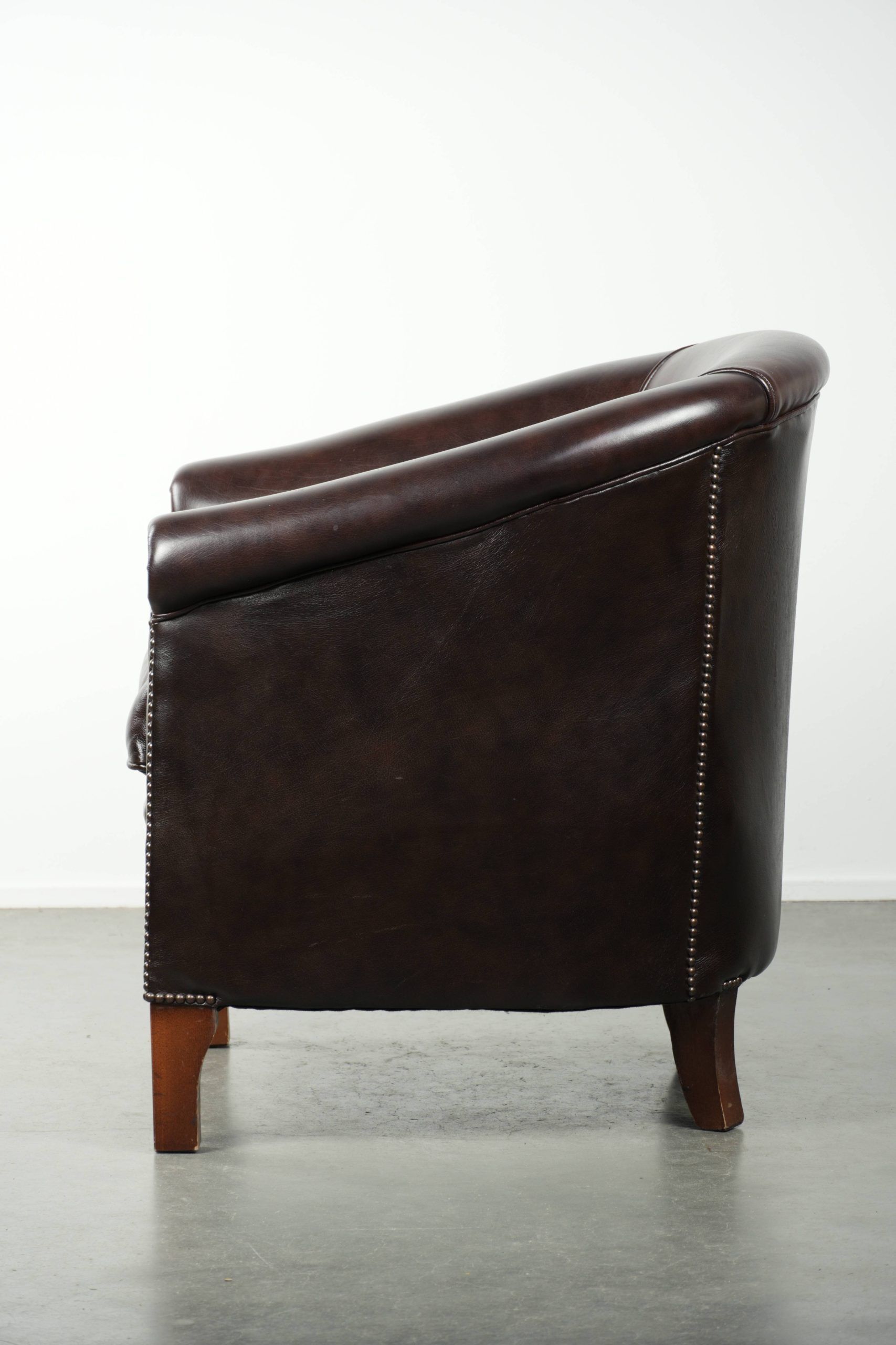 Dark cow leather club armchair with a stylish design in English style